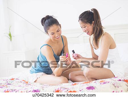 Stock Image - Two women doing manicure. Fotosearch