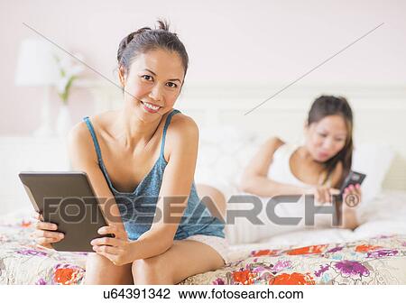 Two women using digital tablet and mobile phone View Large Photo Image Stock Image - Two women using digital tablet and mobile phone. Fotosearch