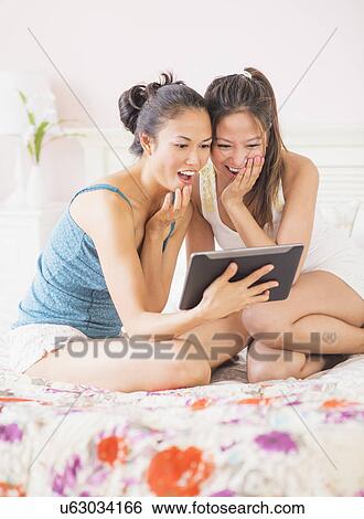 Stock Photograph - Two women using digital tablet. Fotosearch