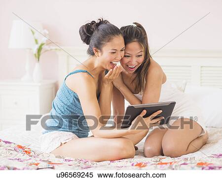 Two women using digital tablet View Large Photo Image Stock Photography - Two women using digital tablet. Fotosearch