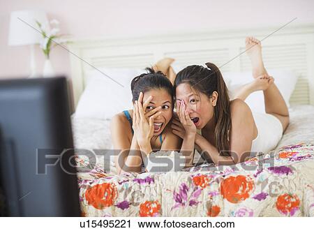 Two women watching tv View Large Photo Image Stock Image - Two women watching tv. Fotosearch