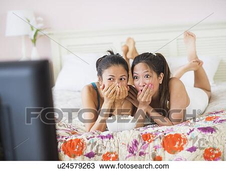 Stock Image - Two women watching tv. Fotosearch