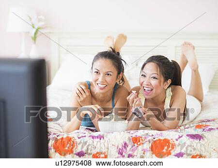 Two women watching tv View Large Photo Image Stock Photo - Two women watching tv. Fotosearch