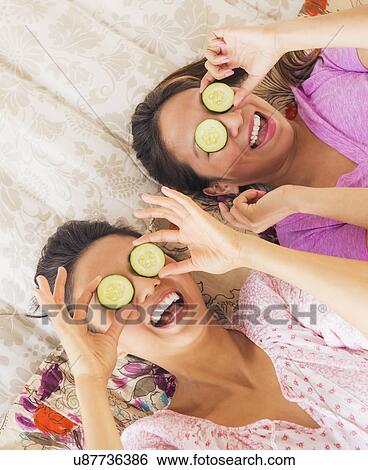 Two women with slices of cucumber on eyes View Large Photo Image Stock Photograph - Two women with slices of cucumber on eyes. Fotosearch