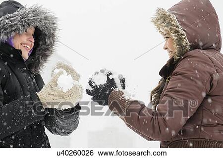 Stock Photograph - Two young women having snowball flight . Fotosearch