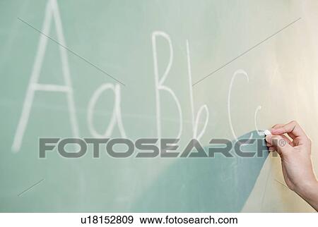 Stock Photo - View of letters on blackboard and girl's hand. Fotosearch