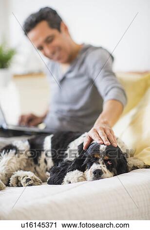 Stock Image - View of mature man petting dog. Fotosearch