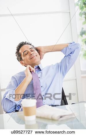 View of mature man relaxing in office View Large Photo Image Stock Photo - View of mature man relaxing in office. Fotosearch