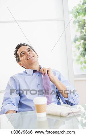 View of mature man relaxing in office View Large Photo Image Stock Photograph - View of mature man relaxing in office. Fotosearch