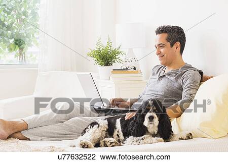 Stock Image - View of mature man using laptop at home. Fotosearch