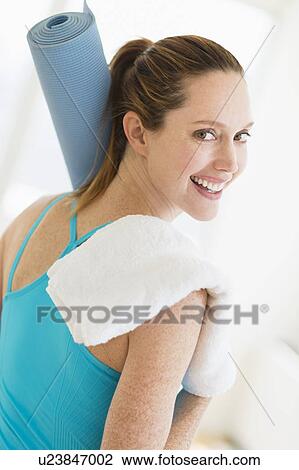 Woman carrying exercise mat and towel View Large Photo Image Stock Image - Woman carrying exercise mat and towel. Fotosearch