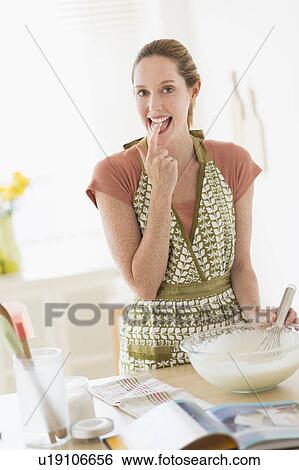 Stock Photograph - Woman cooking in kitchen. Fotosearch