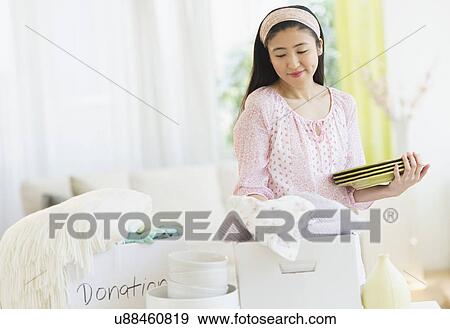 Stock Photo - Woman donating household items. Fotosearch