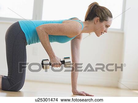 Picture - Woman exercising in gym. Fotosearch