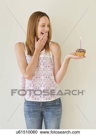 Woman holding birthday cupcake View Large Photo Image Stock Image - Woman holding birthday cupcake. Fotosearch
