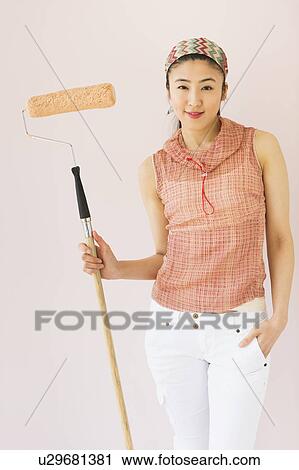 Woman holding paint roller View Large Photo Image Stock Image - Woman holding paint roller. Fotosearch