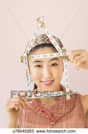 Stock Image - Woman holding tape measure . Fotosearch