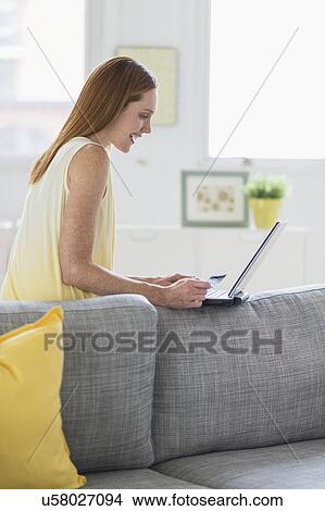 Woman using laptop at home View Large Photo Image Picture - Woman using laptop at home. Fotosearch