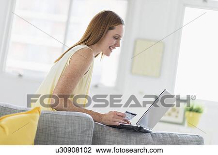 Woman using laptop at home View Large Photo Image Stock Image - Woman using laptop at home. Fotosearch