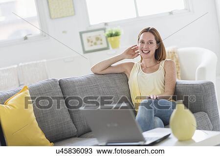 Woman using laptop at home View Large Photo Image Stock Image - Woman using laptop at home. Fotosearch