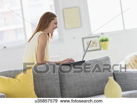Woman using laptop at home View Large Photo Image Stock Photo - Woman using laptop at home. Fotosearch