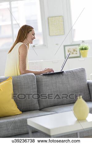 Stock Photo - Woman using laptop at home. Fotosearch