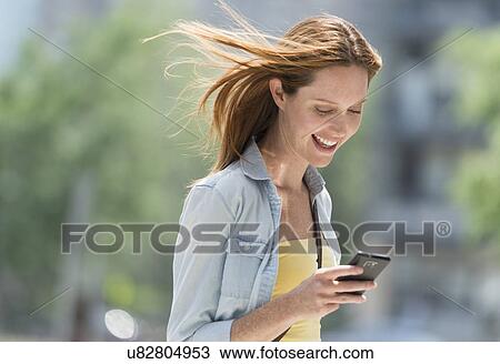 Stock Image - Woman using phone. Fotosearch