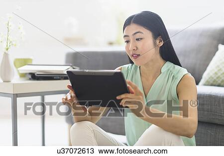 Woman using tablet pc at home View Large Photo Image Stock Image - Woman using tablet pc at home. Fotosearch