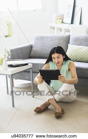 Stock Photo - Woman using tablet pc at home. Fotosearch