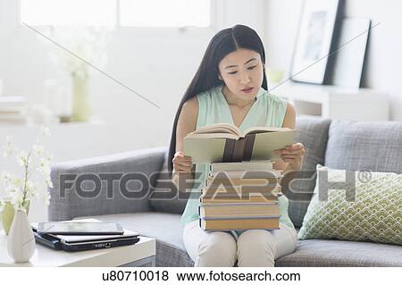 Woman with stack of books at home View Large Photo Image Stock Photo - Woman with stack of books at home. Fotosearch