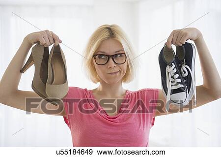 Stock Photo - Young woman choosing shoes. Fotosearch