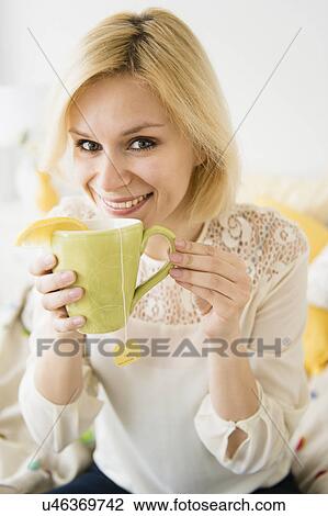Stock Image - Young woman drinking tea. Fotosearch
