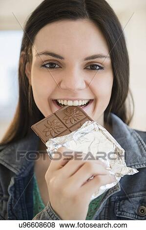 Young woman eating bar of chocolate View Large Photo Image Stock Photo - Young woman eating bar of chocolate. Fotosearch