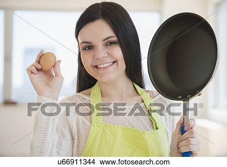 Young woman holding frying pan and egg View Large Photo Image Picture - Young woman holding frying pan and egg. Fotosearch