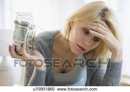 Young woman holding jar with banknotes View Large Photo Image Stock Image - Young woman holding jar with banknotes. Fotosearch