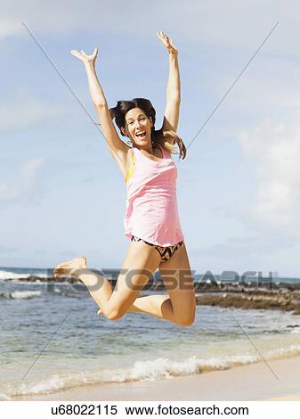 Young woman jumping on beach View Large Photo Image Stock Photography - Young woman jumping on beach. Fotosearch