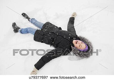 Young woman making snow angel View Large Photo Image Stock Photo - Young woman making snow angel. Fotosearch