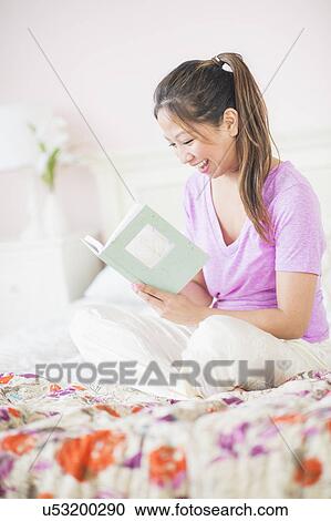 Stock Image - Young woman reading book. Fotosearch