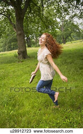 Young woman running in park View Large Photo Image Stock Image - Young woman running in park. Fotosearch