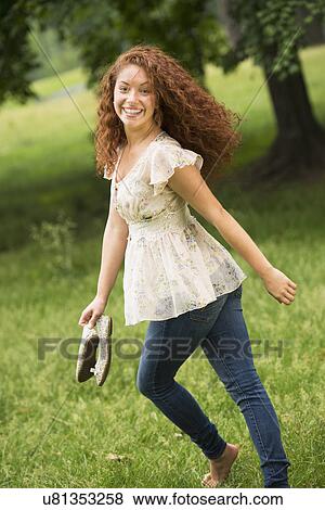 Stock Photo - Young woman running in park. Fotosearch