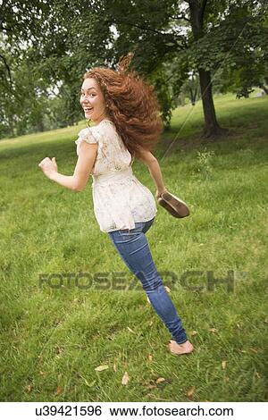 Young woman running in park View Large Photo Image Stock Photograph - Young woman running in park. Fotosearch