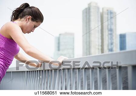Young woman stretching by railing View Large Photo Image Stock Image - Young woman stretching by railing. Fotosearch