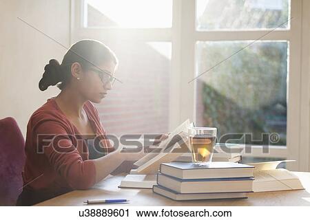 Young woman studying books at desk View Large Photo Image Stock Image - Young woman studying books at desk. Fotosearch