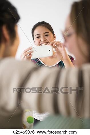 Young woman taking picture with mobile phone View Large Photo Image Stock Photograph - Young woman taking picture with mobile phone. Fotosearch