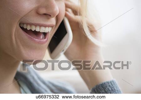 Stock Image - Young woman talking on mobile phone. Fotosearch