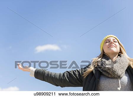 Young woman under blue sky View Large Photo Image Stock Image - Young woman under blue sky. Fotosearch