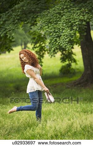 Stock Photo - Young woman walking in park. Fotosearch