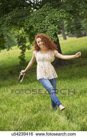Stock Photograph - Young woman walking in park. Fotosearch