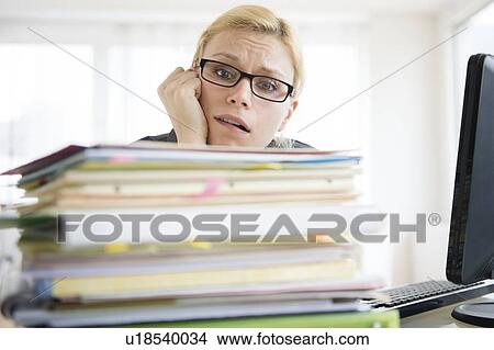 Young woman working at desk in office View Large Photo Image Picture - Young woman working at desk in office. Fotosearch
