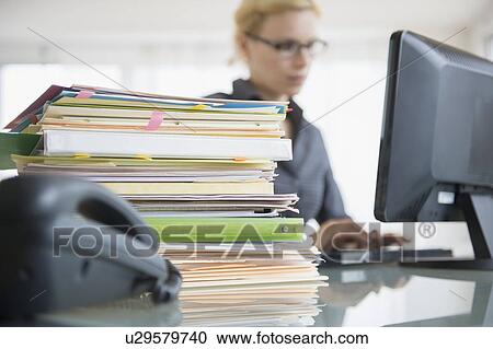 Young woman working at desk in office View Large Photo Image Stock Image - Young woman working at desk in office. Fotosearch